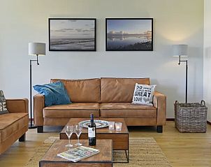 Gezellige woonkamer in Vitamaris appartement op Schiermonnikoog, ideaal voor ontspanning.