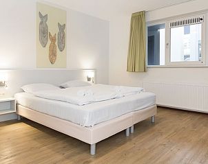 Slaapkamer in Vitamaris 4-persoons appartement op Schiermonnikoog, met tweepersoonsbed en decor.