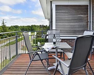Balkon in Vitamaris appartement op Schiermonnikoog, met zitje en uitzicht op de omgeving.