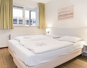 Ruime slaapkamer in Vitamaris appartement op Schiermonnikoog, met comfortabele bedden.