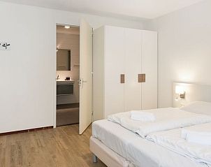 Slaapkamer met ensuite in Vitamaris appartement op Schiermonnikoog, met moderne inrichting.