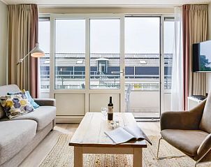 Moderne woonkamer met balkon in Vitamaris appartement, Schiermonnikoog, Waddeneilanden.