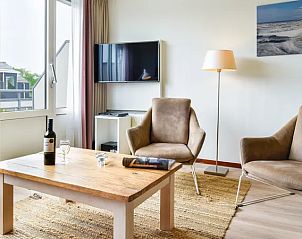 Zithoek met tv en lamp in Vitamaris appartement, Schiermonnikoog, Waddeneilanden.