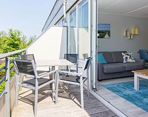Balkon met zitje en uitzicht op groen in Vitamaris appartement, Schiermonnikoog, Waddeneilanden.