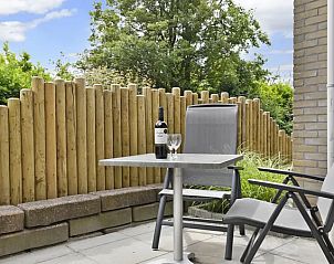 Privterras met tuinstoelen bij Vitamaris appartement, Schiermonnikoog.