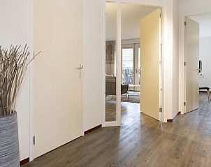 Ruime hal in Vitamaris appartement, Schiermonnikoog, met toegang tot verschillende kamers.