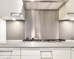 Strakke keuken met roestvrijstalen afwerking in Vitamaris appartement, Schiermonnikoog.