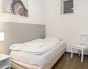 Slaapkamer met uitzicht op woonkamer in Vitamaris appartement, Schiermonnikoog.