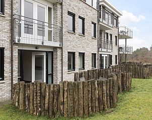 Buitenzijde van Vitamaris appartement op Schiermonnikoog met balkon en groene omgeving.