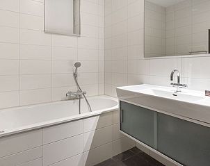 Badkamer met ligbad en moderne wastafel in Vitamaris 2-persoons appartement op Schiermonnikoog.
