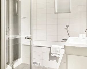 Elegante badkamer van Vitamaris appartement op Schiermonnikoog met douche en ligbad.