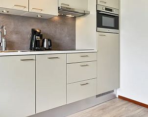 Compacte keuken met moderne apparatuur in Vitamaris appartement, Schiermonnikoog, Waddeneilanden.