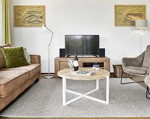 Comfortabele zithoek in Vitamaris 4-persoons appartement 4L2, Schiermonnikoog, met een flatscreen tv en stijlvolle meubels.