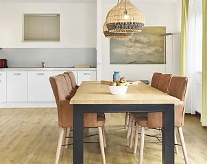Eetgedeelte van Vitamaris 4-persoons appartement 4L2 op Schiermonnikoog met houten tafel en moderne keuken.