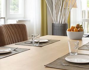 Gedekte eettafel in Vitamaris 4-persoons appartement 4L2, Schiermonnikoog, perfect voor gezellige maaltijden.