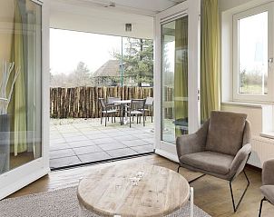 Lichte zithoek in Vitamaris 4-persoons appartement 4L2, Schiermonnikoog, met uitzicht op het terras en de natuur.