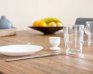 Gedekte tafel in Vitamaris appartement, Schiermonnikoog, klaar voor een gezellige maaltijd.