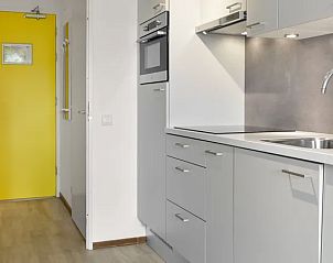 Ingang van de keuken in Vitamaris appartement, Schiermonnikoog, met opvallende gele deur.