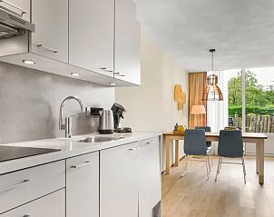 Keuken en eetruimte in Vitamaris appartement op Schiermonnikoog met uitzicht op tuin.