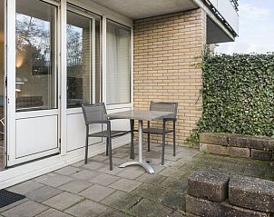 Privterras van Vitamaris appartement op Schiermonnikoog met groene haag.