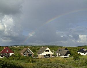 Regenboog boven Casa Maris vakantiehuis op Schiermonnikoog, omgeven door duinen, Waddeneilanden.