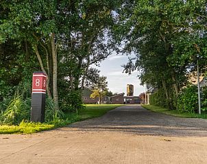 Ingang van Huisje in Schiermonnikoog, vakantieverblijf in Schiermonnikoog, Waddeneilanden, omgeven door bomen.