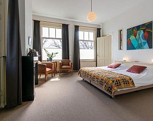 Lichte slaapkamer in B&B De Postoari Terschelling, Hoorn, met comfortabele bedden en kunst aan de muur.