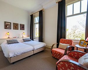 Ruime slaapkamer met tweepersoonsbed in B&B De Postoari Terschelling, Hoorn, met uitzicht op de natuur.