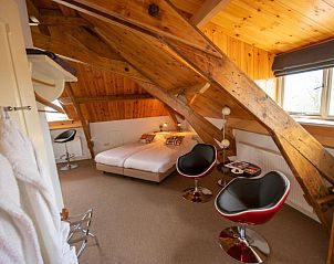 Knusse zolderkamer met houten balken in B&B De Postoari Terschelling, Hoorn, perfect voor een ontspannen verblijf.