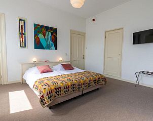 Stijlvolle slaapkamer met kunst in B&B De Postoari Terschelling, Hoorn, voor een inspirerende omgeving.