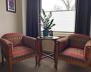 Comfortabele zithoek met planten in B&B De Postoari Terschelling, Hoorn, voor een huiselijke sfeer.