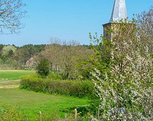 Uitzicht op de kerk vanuit B&B De Postoari Terschelling, Hoorn, omgeven door groene natuur.