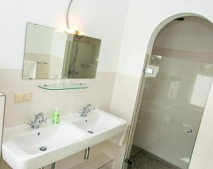 Moderne badkamer met dubbele wastafel in B&B De Postoari Terschelling, Hoorn, voor extra comfort.