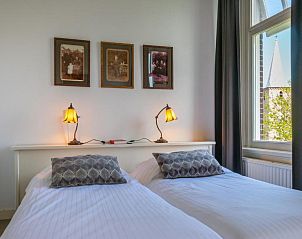 Slaapkamer met historische foto's in B&B De Postoari Terschelling, Hoorn, voor een nostalgische sfeer.