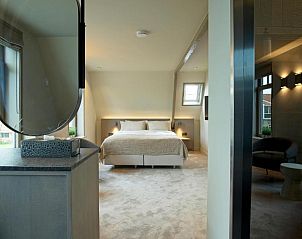 Stijlvolle slaapkamer met spiegel in Hotel De Koegelwieck Terschelling, vakantieappartement in Hoorn, Waddeneilanden.