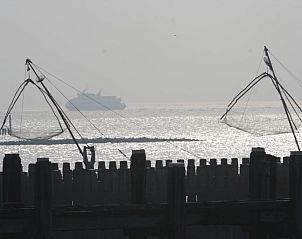 Zeezicht met vissersnetten nabij Hotel Restaurant Piccard, Vlissingen, Walcheren, Zeeland bij zonsondergang.