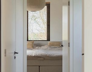 Doorkijk naar de slaapkamer in Vakantiehuis in Makkum, met serene en lichte inrichting.