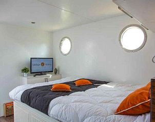 Gezellige binnenruimte van vakantiehuis FR060 in Warns, met uitzicht op jachthaven en comfortabele zithoek aan het IJsselmeer, Friese meren.