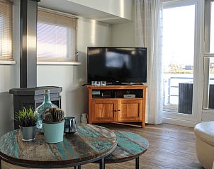 Cozy living room in Holiday Home in Oudega overlooking Heeg Lake, Frisian Lakes, equipped with wood stove and modern furnishings.