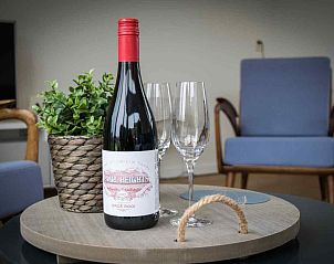 Comfortabel terras bij vakantiehuis FR061, Koudum, met loungebank en groene omheining.