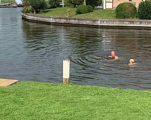 Lichte woonkamer in vakantiehuis FR061, Koudum, met panoramische ramen en moderne meubels.