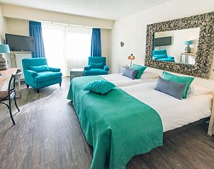 Ruime kamer in Hotel De Walvisvaarder, Lies, Terschelling met moderne faciliteiten en grote spiegel.