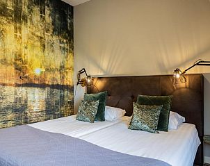 Sfeervolle slaapkamer in Hotel De Walvisvaarder, Lies, Terschelling met artistieke muurschildering.