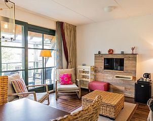 Lichte woonkamer in Hotel De Walvisvaarder, Lies, Terschelling met uitzicht op het terras.