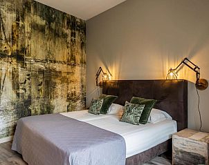 Elegante slaapkamer in Hotel De Walvisvaarder, Lies, Terschelling met artistieke wanddecoratie.