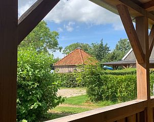 Uitzicht vanaf de veranda van Vakantiehuis in Elahuizen, met groene omgeving van Fluessen.