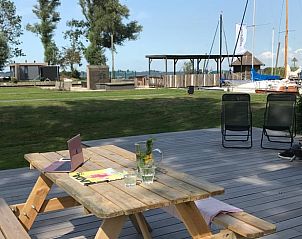 Terras van Vakantiehuis in Elahuizen met uitzicht op de jachthaven en groene omgeving.