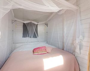 Sfeervolle slaapkamer in Vakantiehuis in Elahuizen met hemelbed en zachte verlichting.
