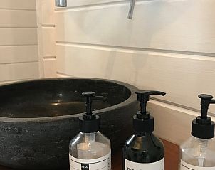 Zwarte wastafel in Vakantiehuis in Elahuizen met verzorgingsproducten.