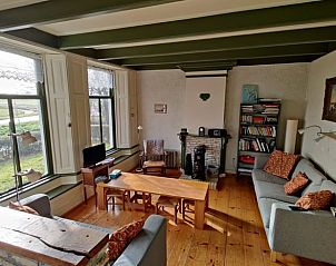 Comfortabele woonkamer in vakantiehuis Gaastmeer, met houten vloeren en uitzicht op de Friese meren.